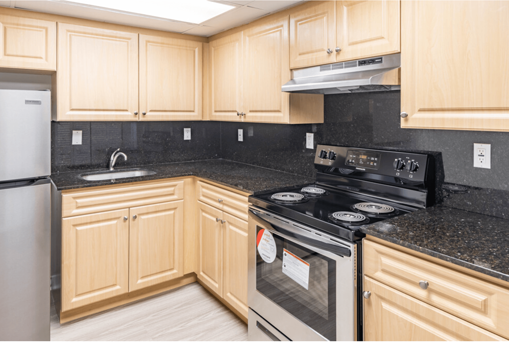a kitchen with wooden cabinets and black granite countertops a kitchen with wooden cabinets and black granite countertops at Lakeside @ Biscayne Gardens,North Miami,33181