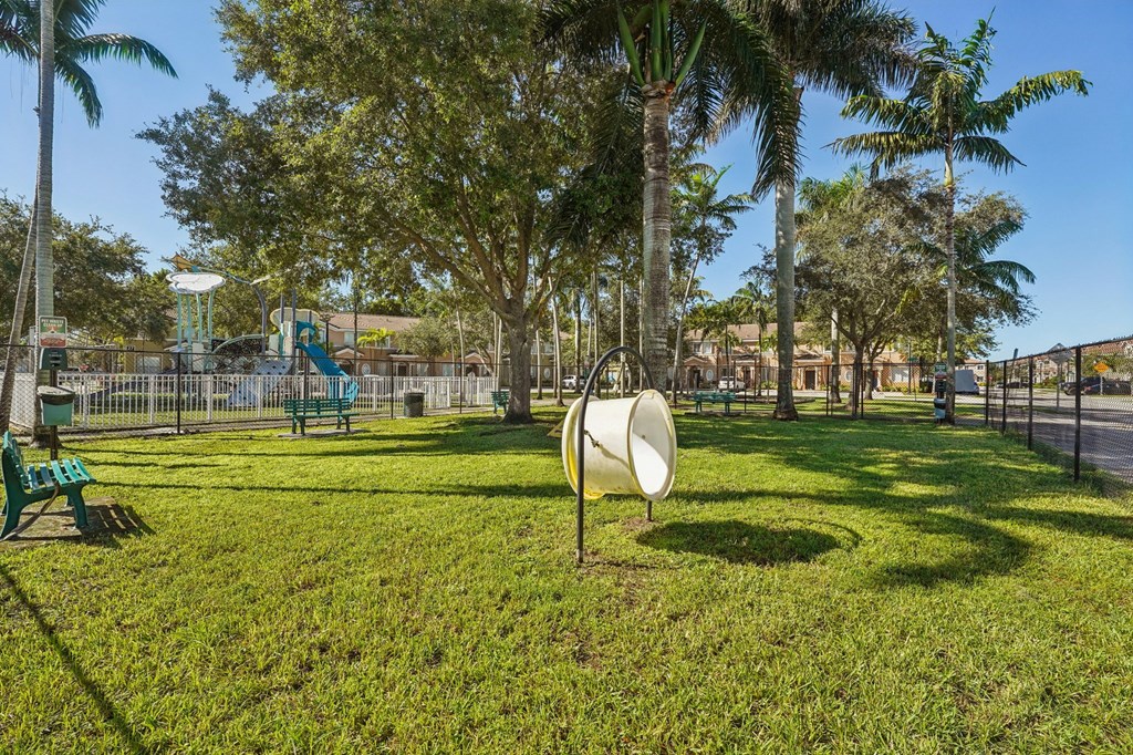 A park with a white circular sign in the middle of the grass.