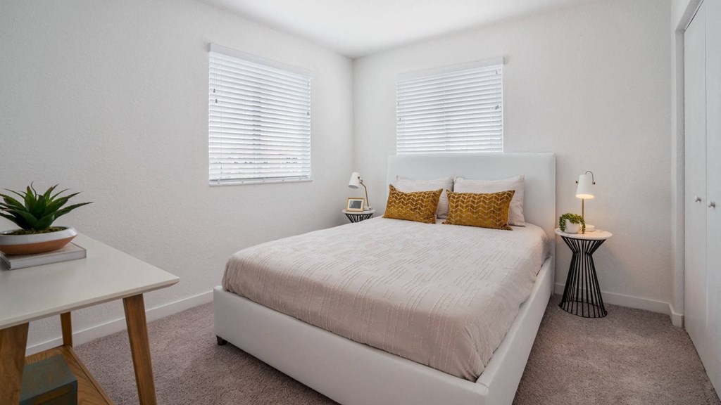 a bedroom with a bed and two windows