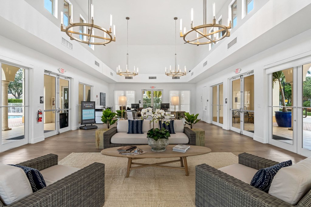 a living room with couches and chairs and chandeliers