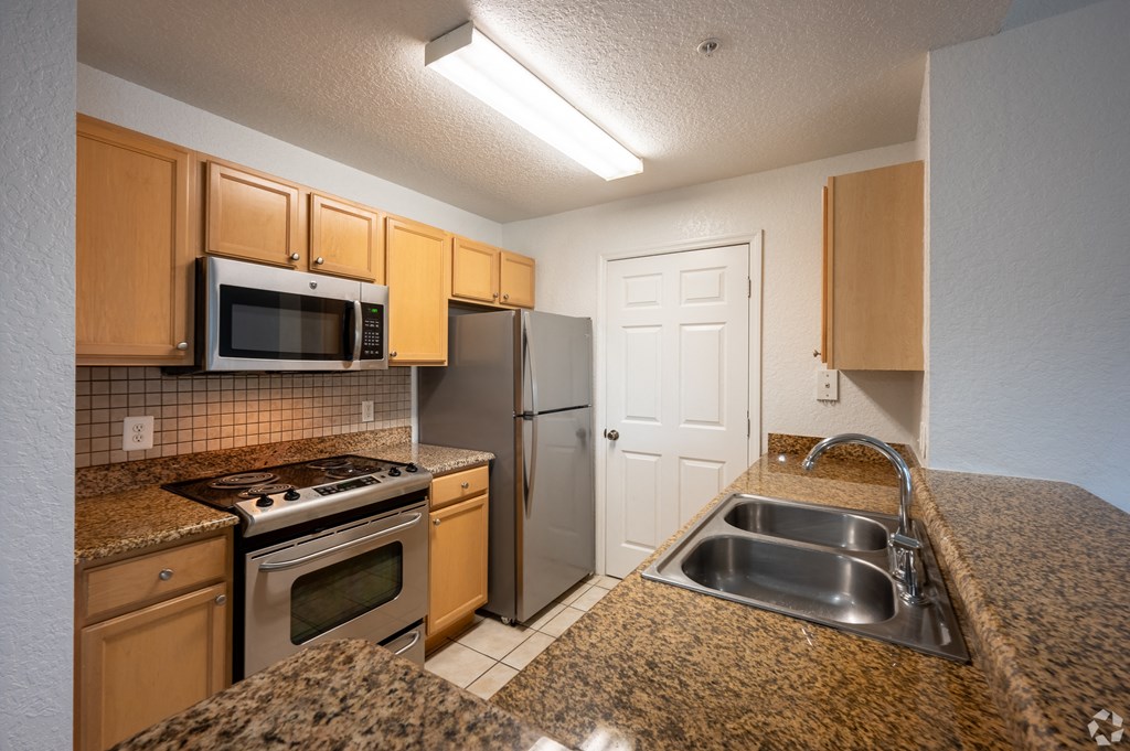 Kitchen with microwave, stove and refrigerator