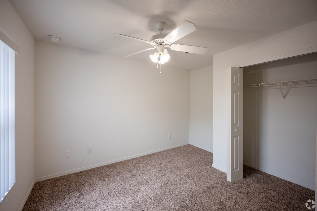 large bedroom with a ceiling fan and walk-in closet