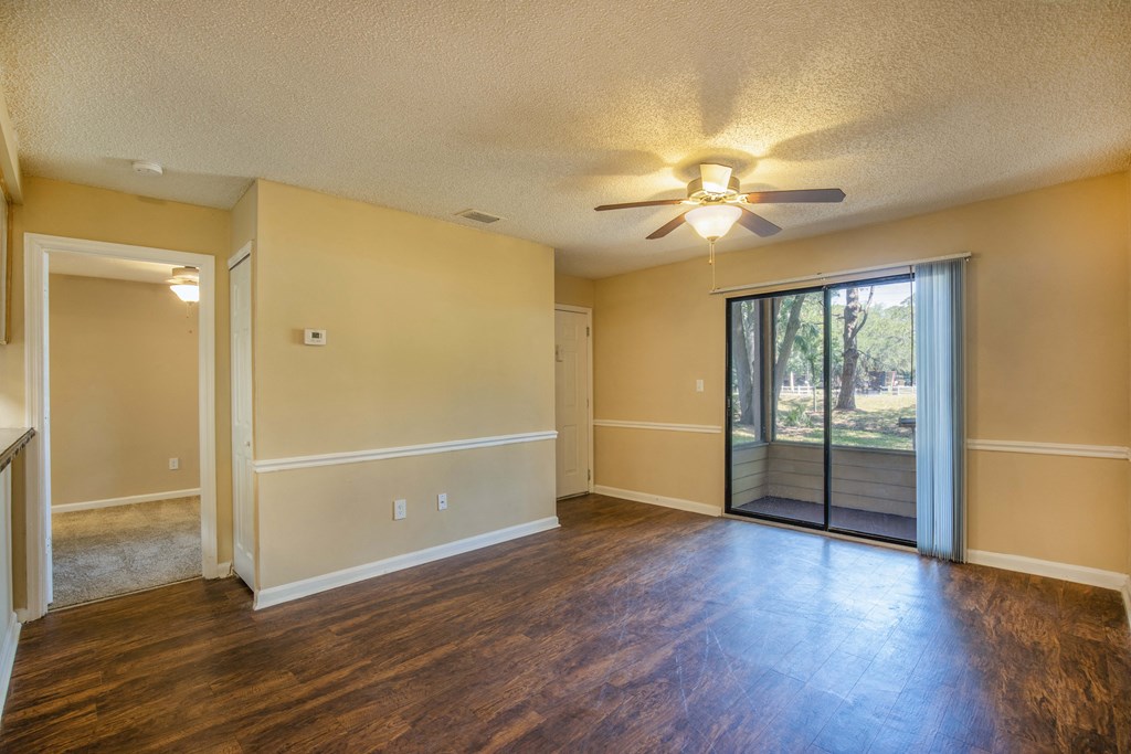 an empty living room with a sliding glass door and a ceiling fan at Lakeside Gardens, Daytona, FL 32114
