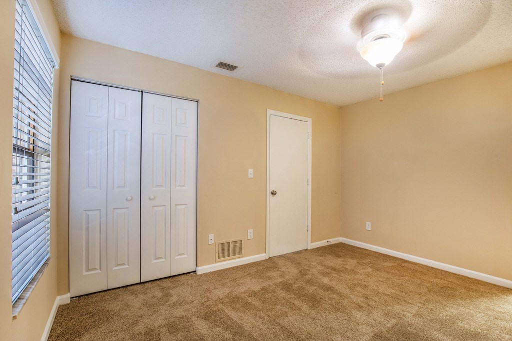 a bedroom with a carpeted floor and two closets at Lakeside Gardens, Daytona, FL