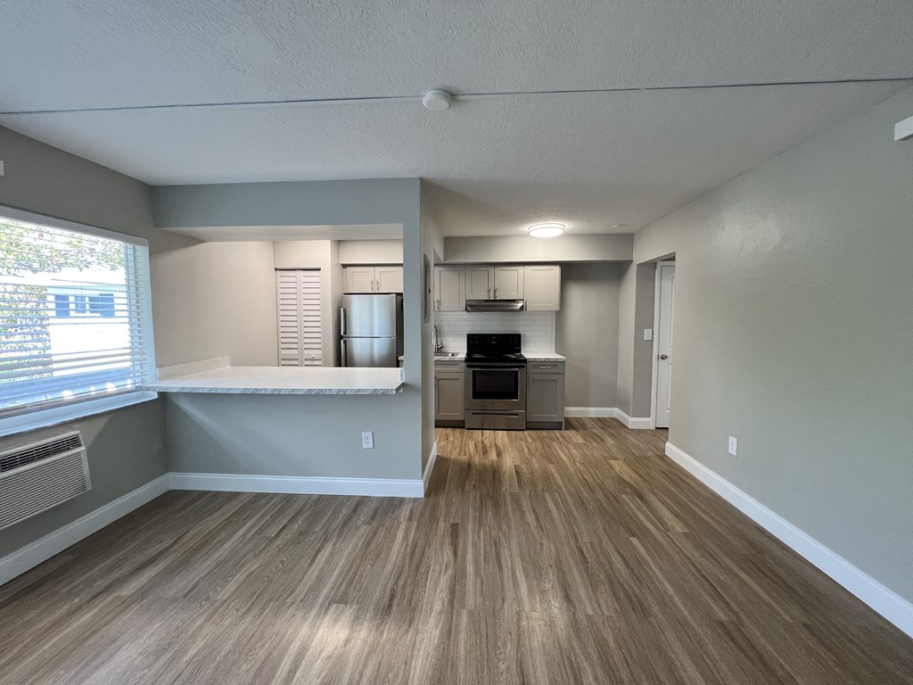 an empty living room and kitchen with a large window  at Palm Gardens @ Biscayne Gardens, North Miami
