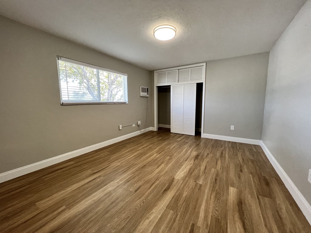an empty living room with hardwood floors and a window  at Palm Gardens @ Biscayne Gardens, North Miami, 33181