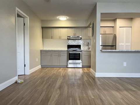 a kitchen with white cabinets and a stove and a refrigerator