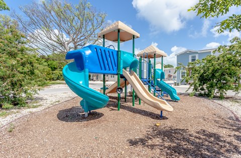 A playground with a blue slide and a yellow top.