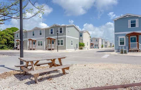 A row of houses with a picnic table in front.