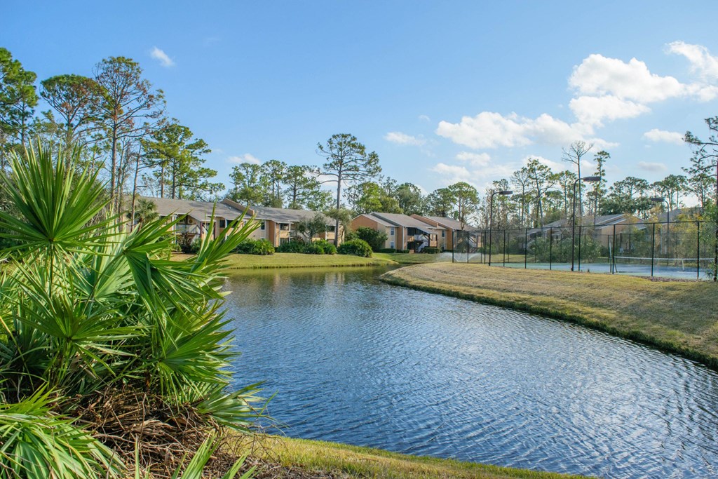 Daytona Apartments a pond with houses in the background at Lakeside Gardens, Daytona, FL