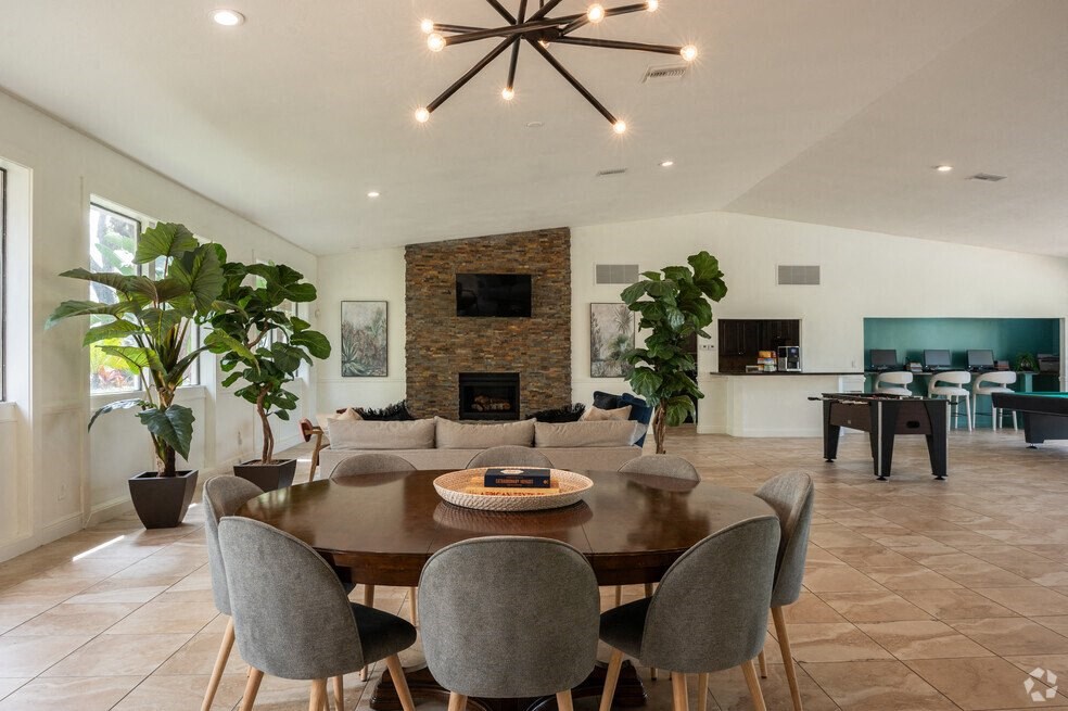 a dining room and living room with a table and chairs at Lakeside Gardens, Daytona