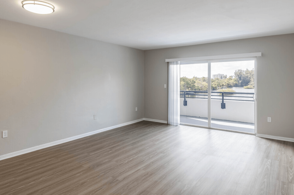 a bedroom with a sliding glass door and hardwood floors at Lakeside @ Biscayne Gardens,North Miami