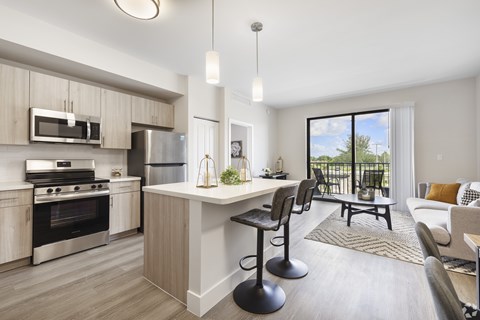 A modern kitchen with a bar stool in front of the island.
