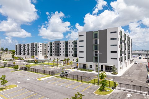 A large white building with a parking lot in front.