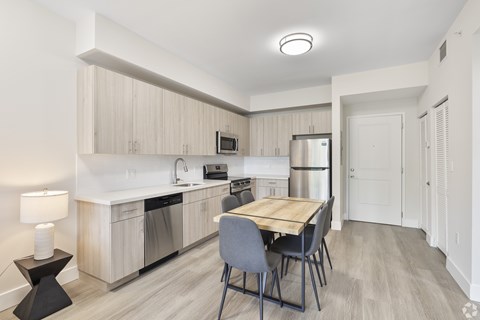 A kitchen with a table and chairs in the middle of the room.