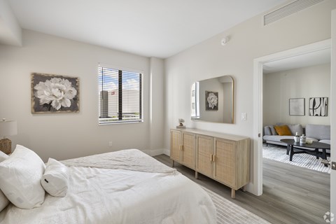 A bedroom with a large bed and a wooden cabinet.