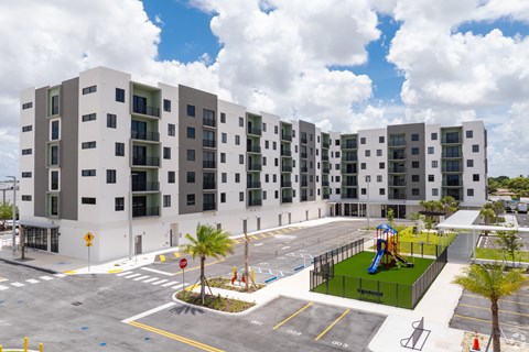 A large white building with a playground in front.