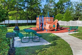 a playground with a swing set and picnic table