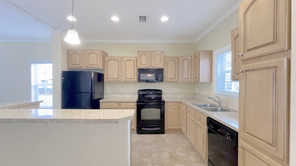 A kitchen with wooden cabinets and black appliances.
