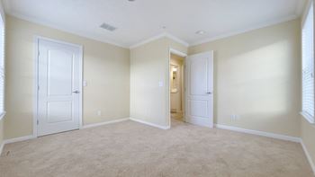 A room with beige carpet and white doors.