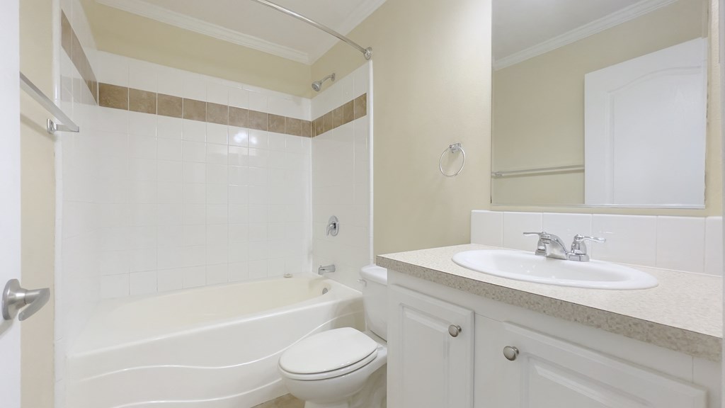 A white bathroom with a toilet, sink, and bathtub.