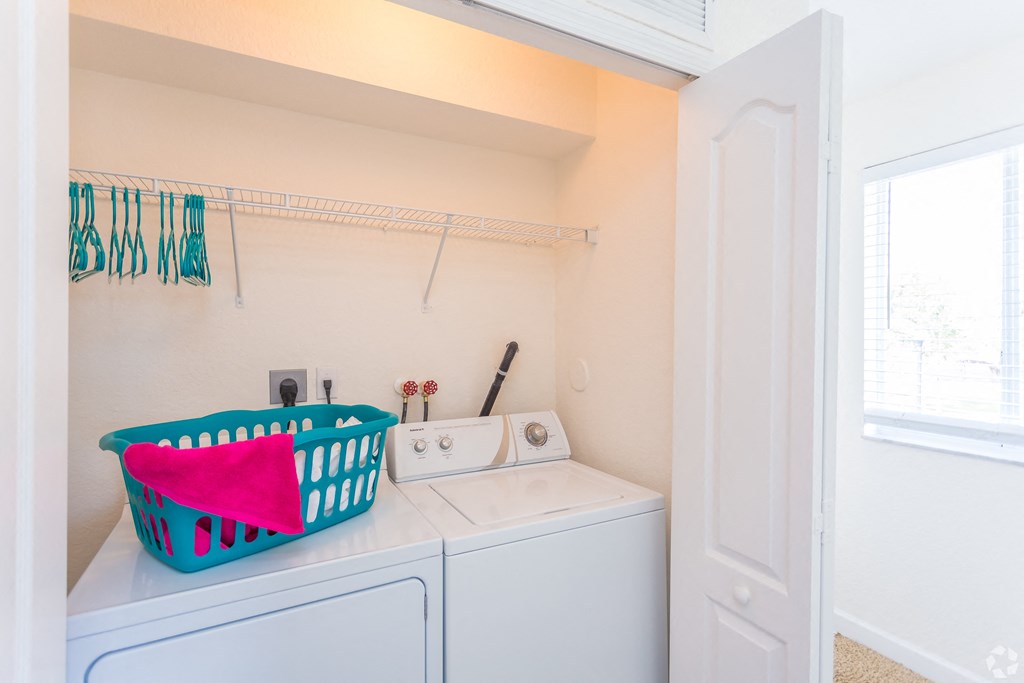 a washer and dryer in a laundry room with a basket