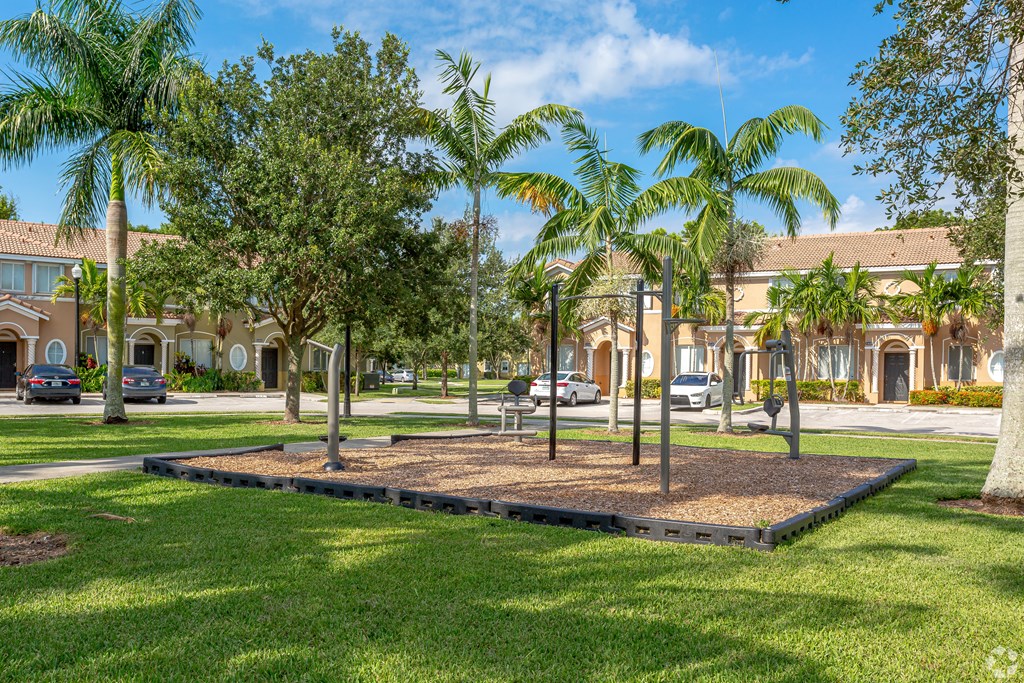 a park with palm trees in front of a building