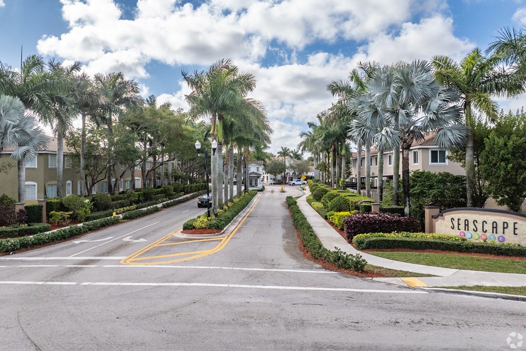 A street view of a residential area with the name "SEASCAPE" on a sign.