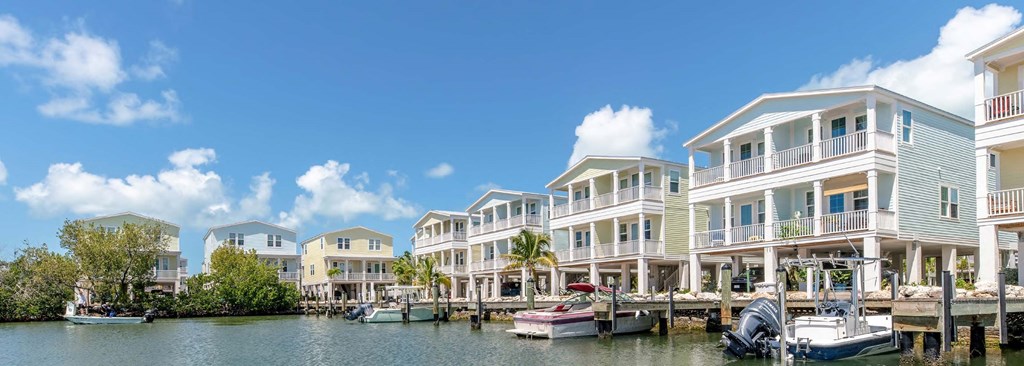 A row of houses are built on stilts over a body of water.