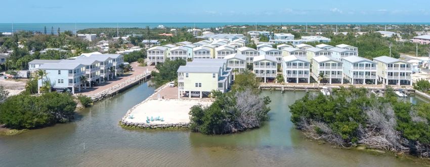 an aerial view of houses next to a body of water