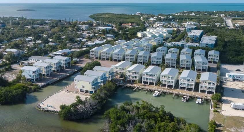 A bird's eye view of a coastal residential area with houses and boats.