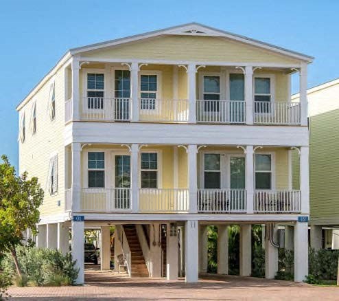 a white and yellow house with a porch