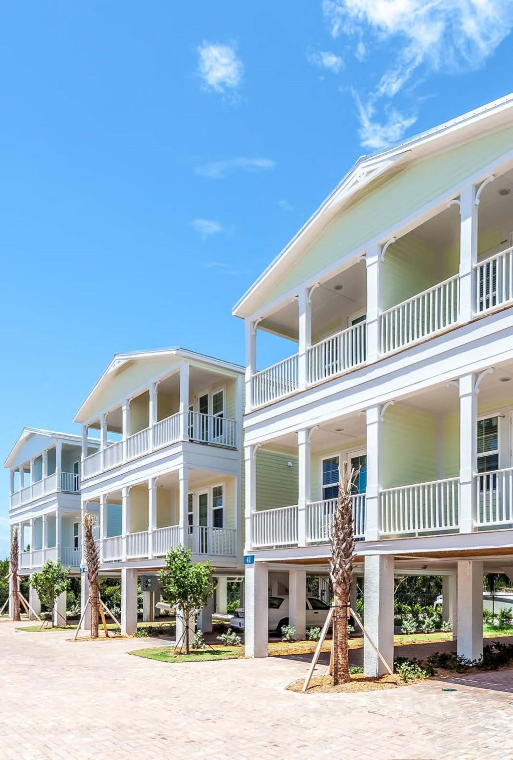 A white two-story building with a balcony on the second floor.