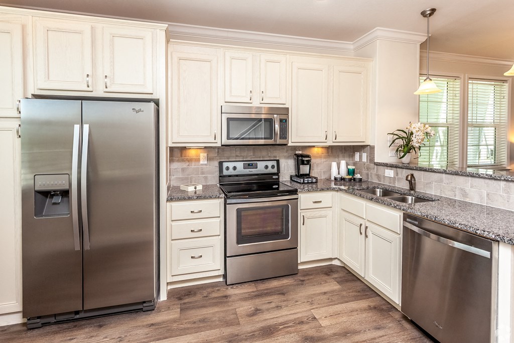 A kitchen with a stainless steel refrigerator and oven.
