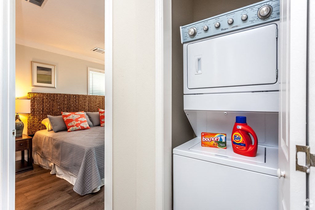 A white oven is open and a bottle of bounce back and a box of bounce it are on the shelf.