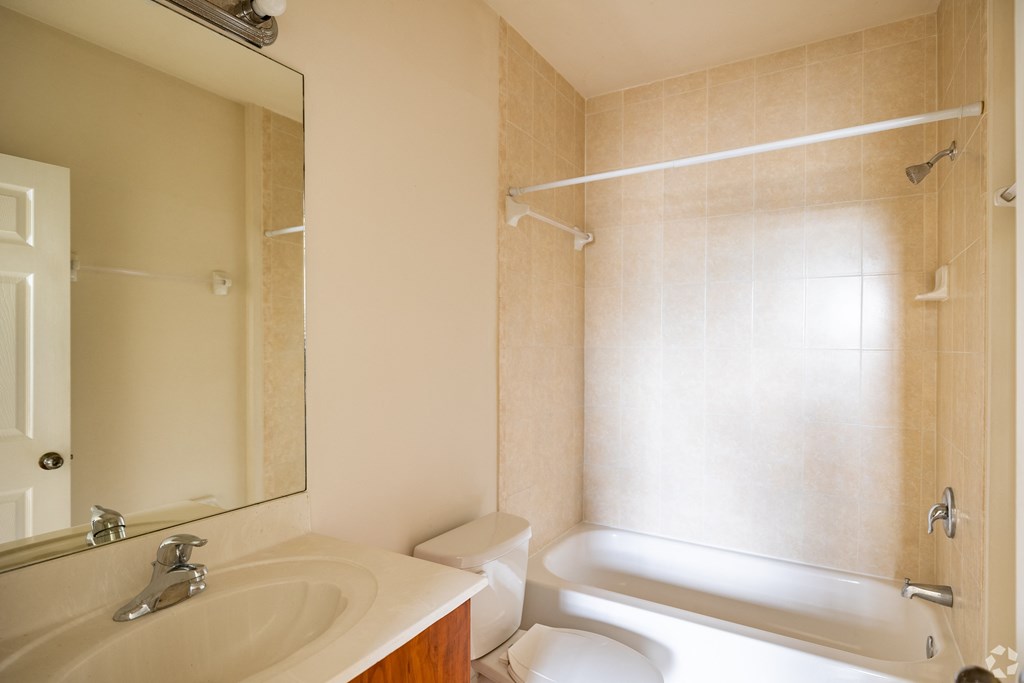 A bathroom with a sink, toilet, and bathtub.