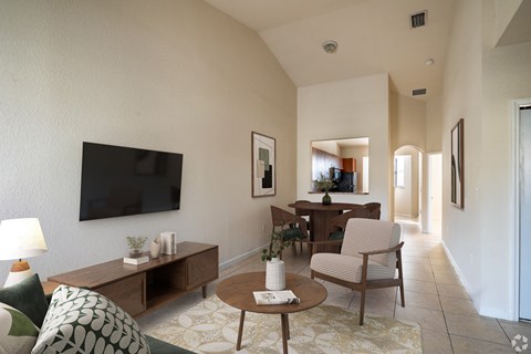 A living room with a flat screen TV mounted on the wall.