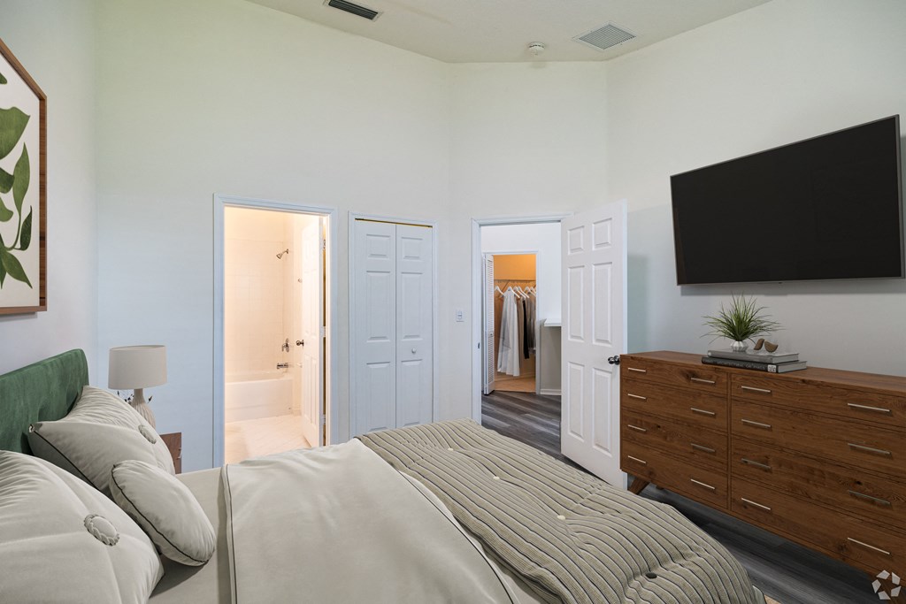 A bedroom with a large bed and a flat screen TV mounted on the wall.