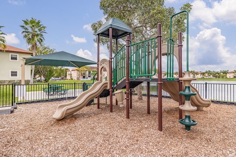 A playground with a green slide and a brown slide.