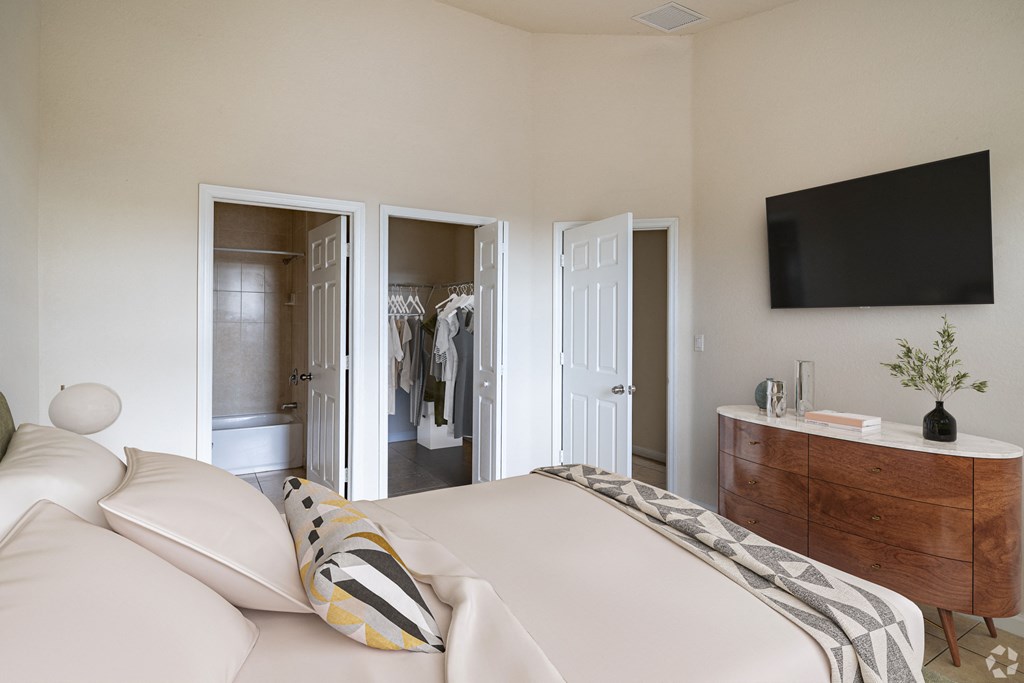 A bedroom with a bed, dresser, and mirror.