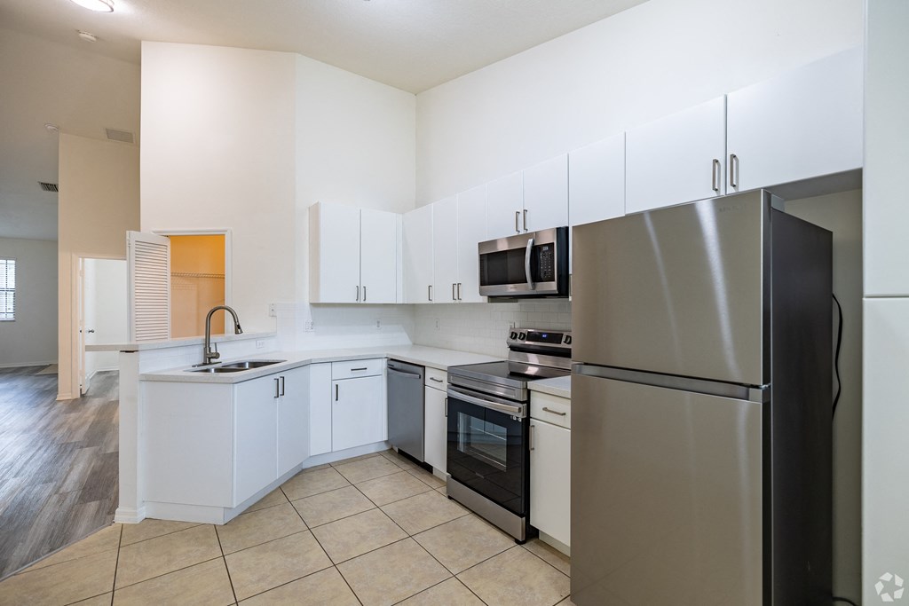 A kitchen with white cabinets and stainless steel appliances.