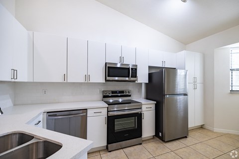 A kitchen with white cabinets and stainless steel appliances.