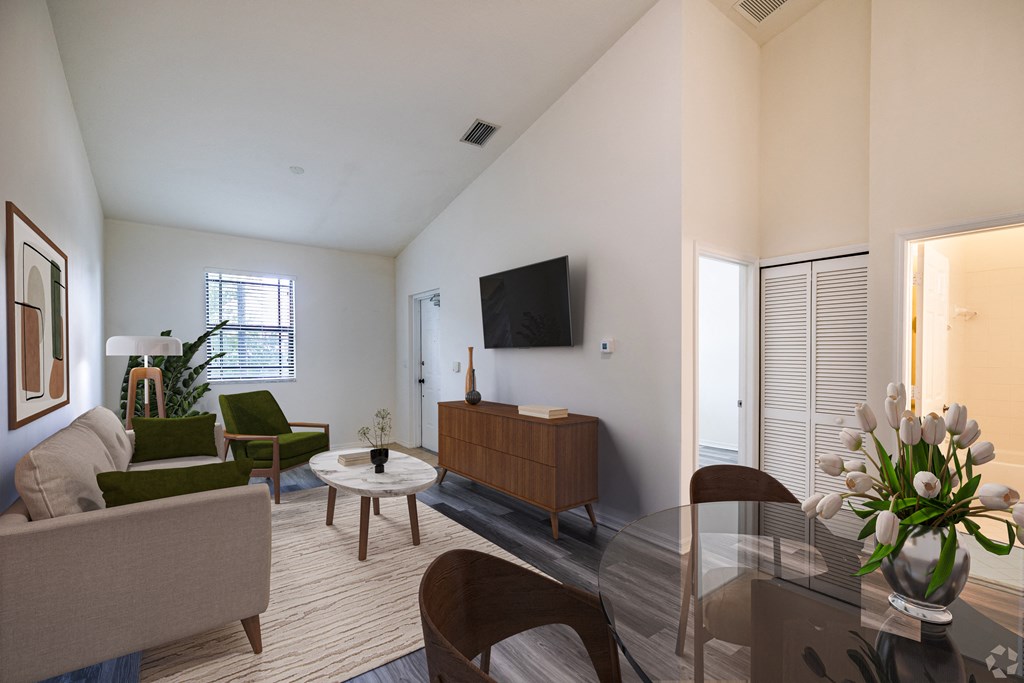 A living room with a couch, chairs, a coffee table, and a television.