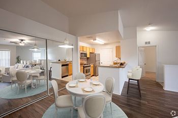 a dining room and kitchen with a table and chairs