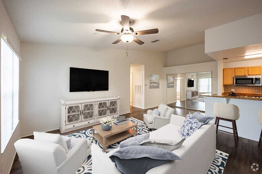 a living room with a white couch and a ceiling fan