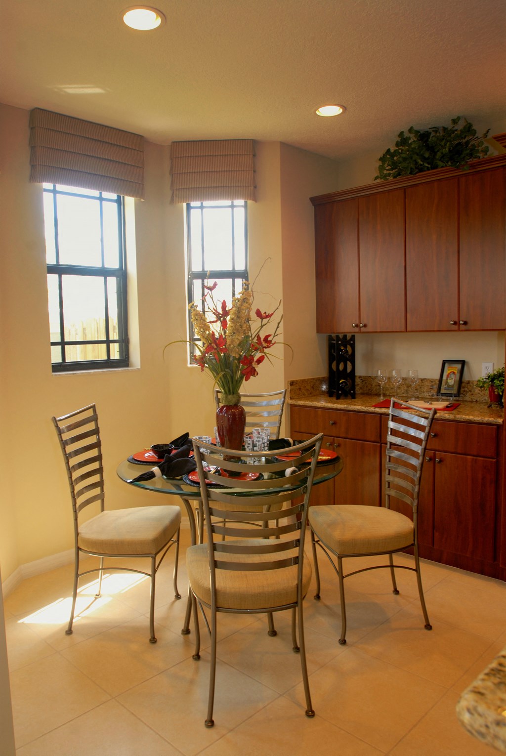 a dining room table with chairs and a vase of flowers