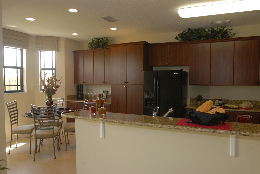 a kitchen with a bar and a table with chairs
