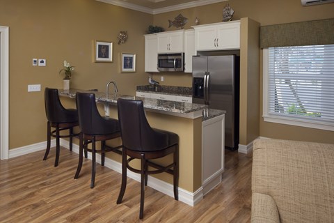 a kitchen with a bar and a stainless steel refrigerator