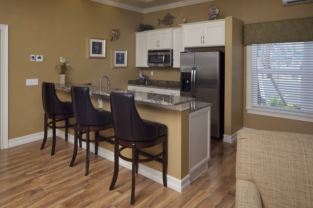 A kitchen with brown chairs and a white fridge. A kitchen with brown chairs and a white fridge.