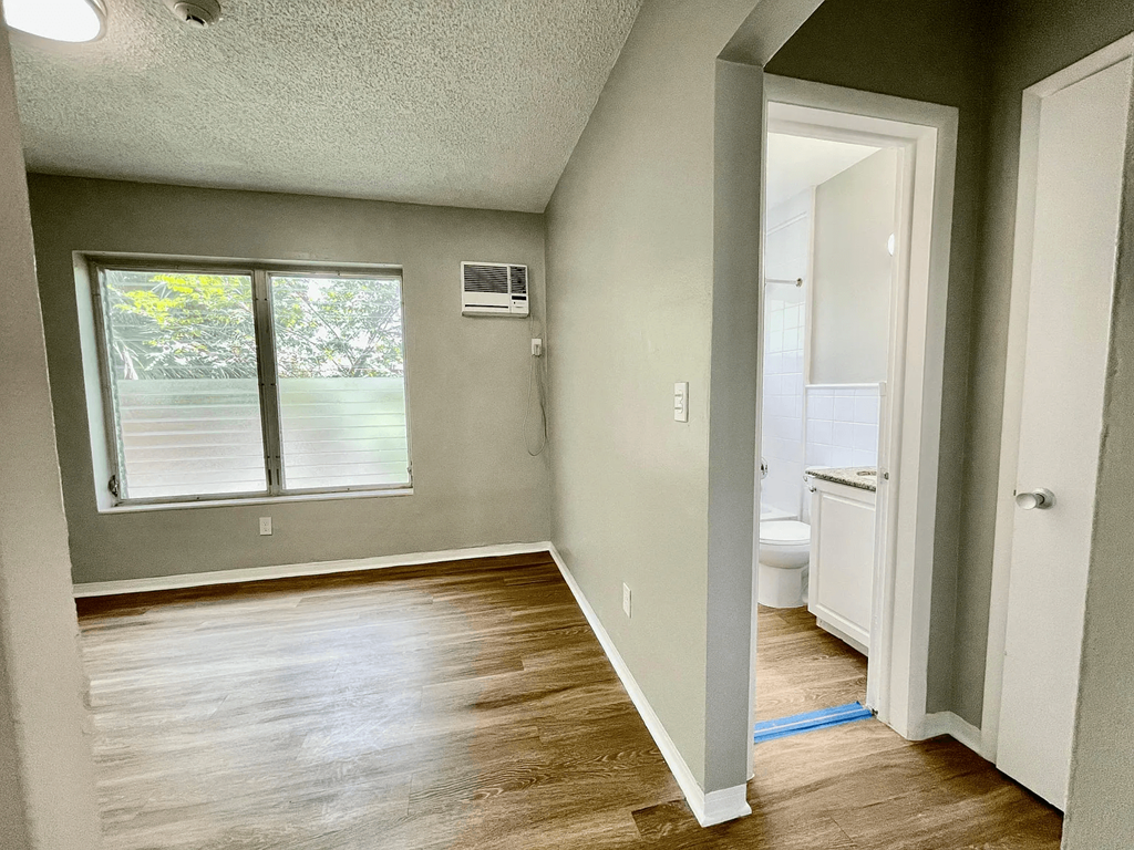 an empty bedroom with a bathroom in the background at Lakeside @ Biscayne Gardens,North Miami, Florida